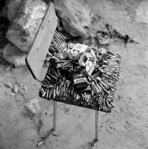 Partially burnt cigarettes lay piled on a chair in a classroom as a mark of respect to relatives who were executed by terrorists at School No. 1, Beslan, North Ossetia, September 2004